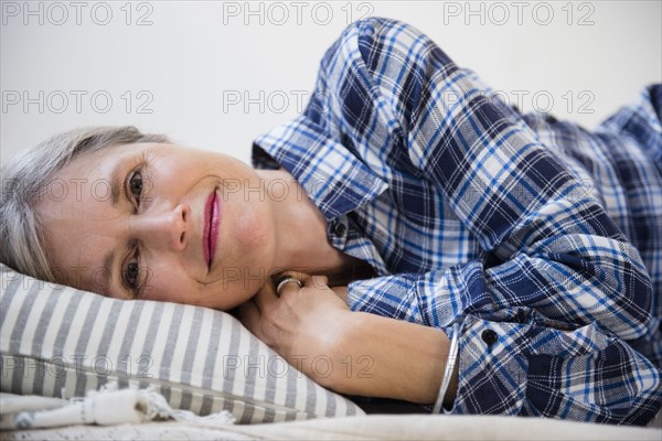 Smiling Caucasian woman laying on pillow