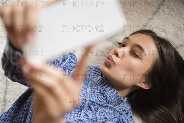 Mixed Race woman posing for cell phone selfie
