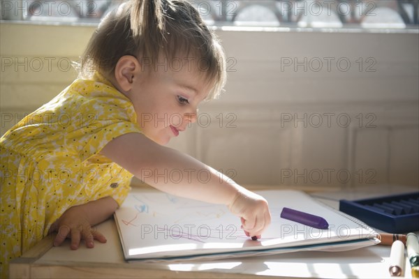 Caucasian baby girl coloring on sketchpad
