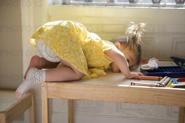 Caucasian baby girl laying on table near window