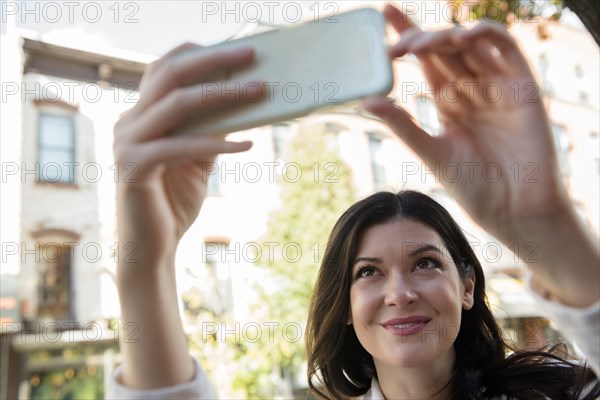 Smiling Caucasian woman posing for cell phone selfie