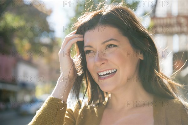 Wind blowing hair of smiling Caucasian woman