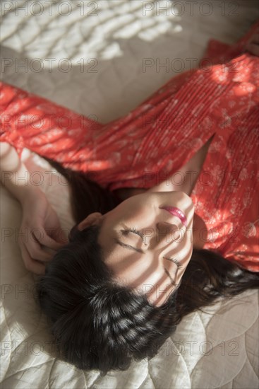 Shadows on Caucasian woman sleeping on bed