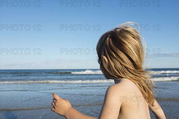 Wind blowing hair of Caucasian girl on beach