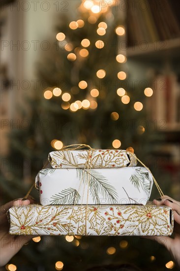 Hands of Caucasian woman holding Christmas gifts