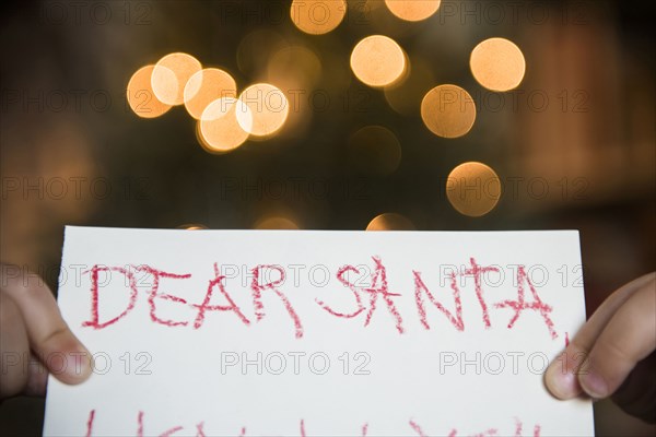 Hands of Caucasian girl holding dear Santa letter