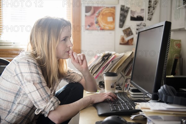 Pensive woman using computer at desk