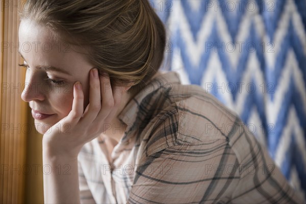 Pensive woman with hand on chin