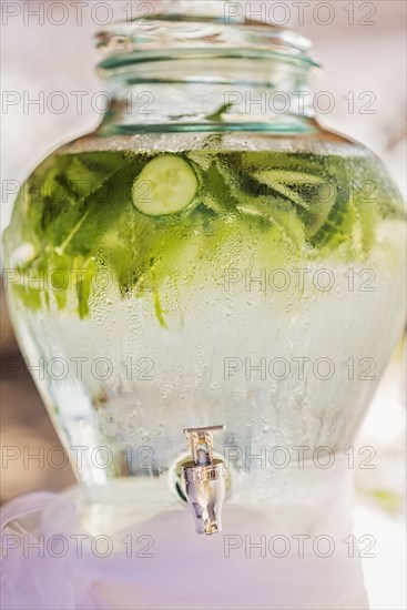 Water beading on vase of water with fresh cucumbers