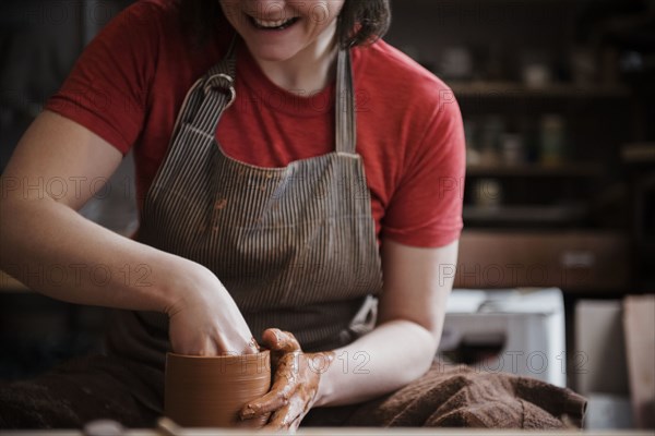 Caucasian woman shaping pottery clay