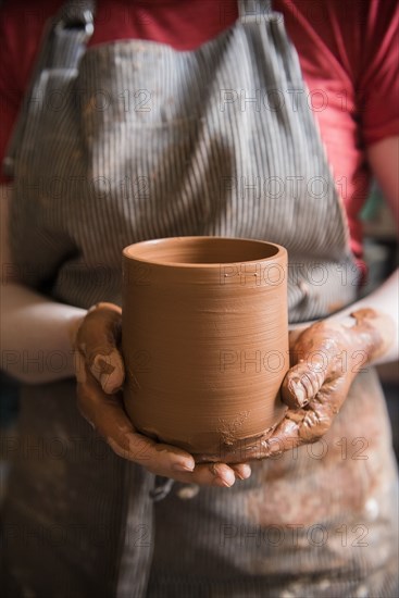 Caucasian woman showing pottery cup