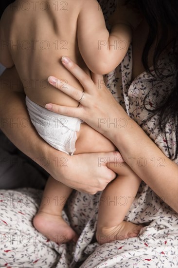 Caucasian mother holding baby son in bed