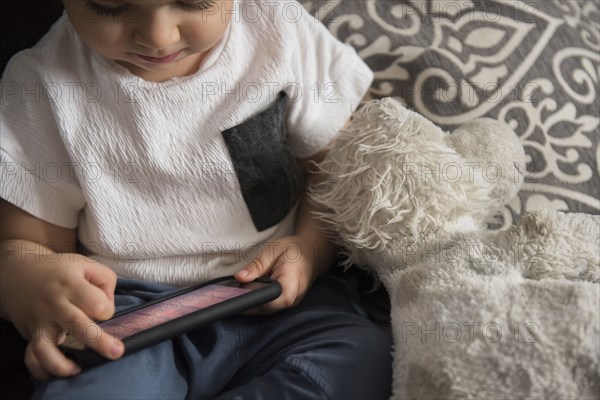 Caucasian boy playing with cell phone