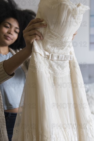 African American woman holding wedding dress