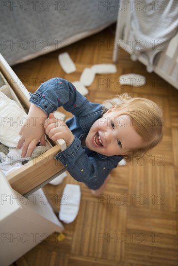 Caucasian girl throwing diapers on floor