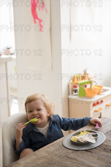 Caucasian girl eating with fork and spoon