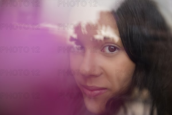 Smiling Hispanic woman behind window