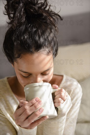 Hispanic woman drinking coffee