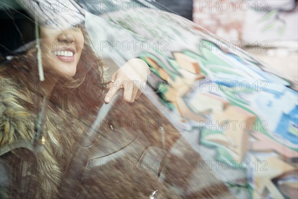 Mixed Race woman behind windshield driving car