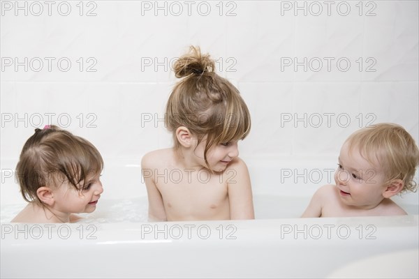 Smiling Caucasian boy and girls in bathtub