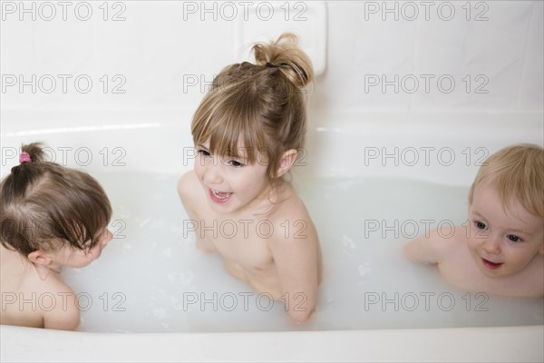 Smiling Caucasian boy and girls in bathtub