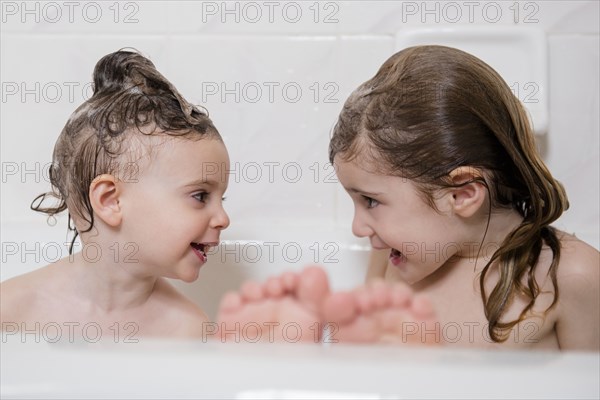 Smiling Caucasian girls in bathtub