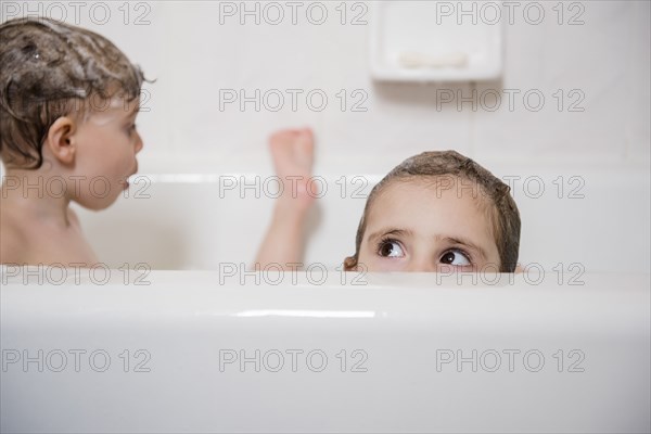 Caucasian girl peaking from bathtub