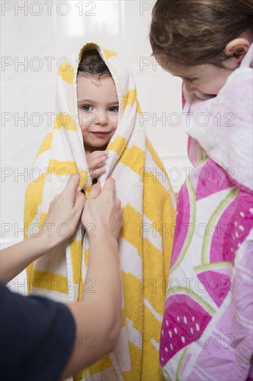 Caucasian mother drying daughters with towels