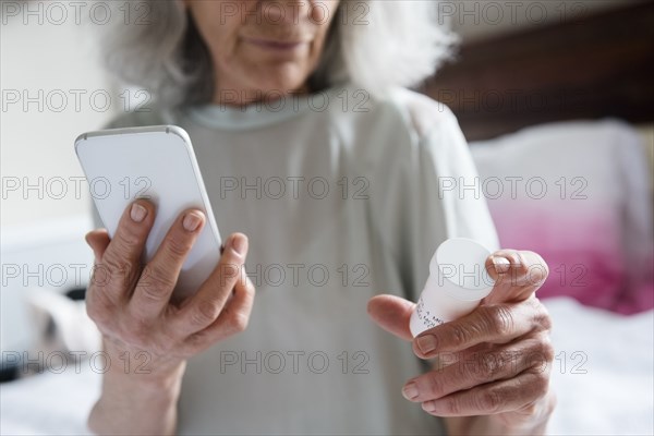 Older woman checking prescription with cell phone