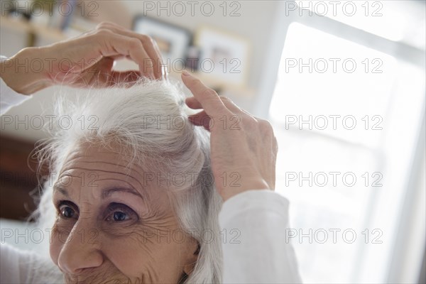 Older woman arranging hair