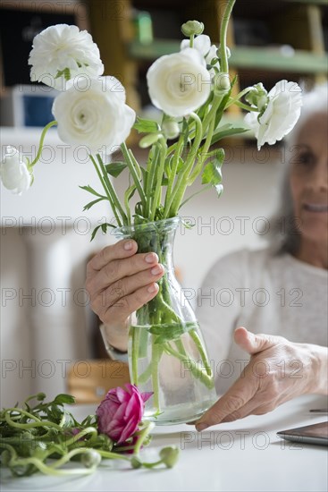 Older woman arranging flowers