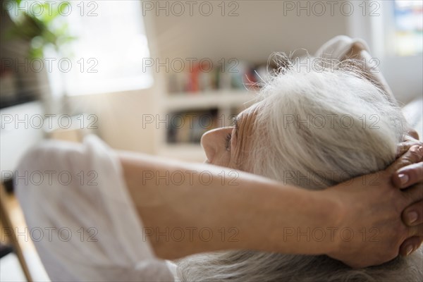 Older woman relaxing with hands behind head