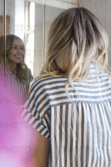 Reflection of smiling Caucasian woman in mirror