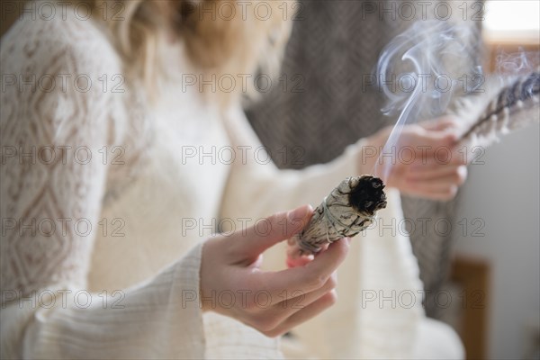 Caucasian woman holding a feather and ritual incense