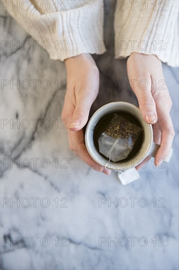 Hands of Caucasian woman holding cup of tea