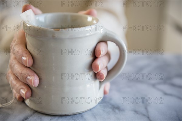 Hands of Caucasian woman holding cup of tea