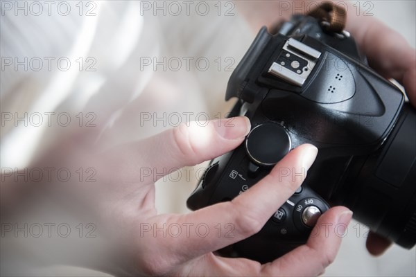 Hands of Caucasian woman turning dial on camera