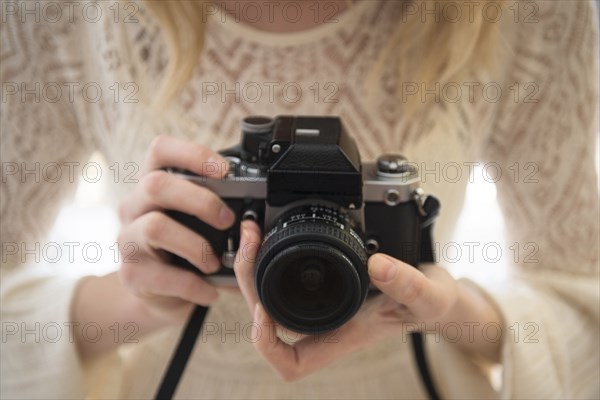 Hands of Caucasian woman focusing lens on camera
