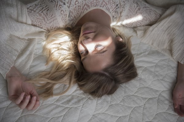 Caucasian woman napping on bed