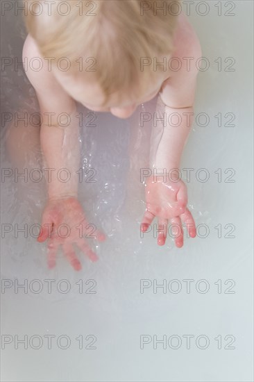 Caucasian baby boy in milk bath