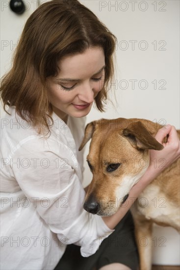 Caucasian woman hugging dog
