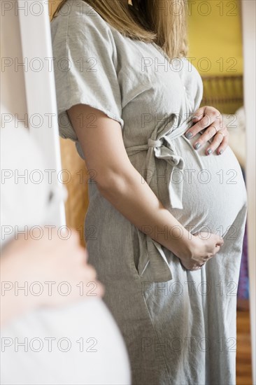 Reflection of Caucasian expectant mother in the mirror