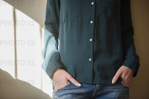 Midsection of Caucasian woman with hands in pockets