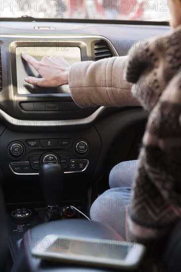 Caucasian woman sitting in car pressing touch screen