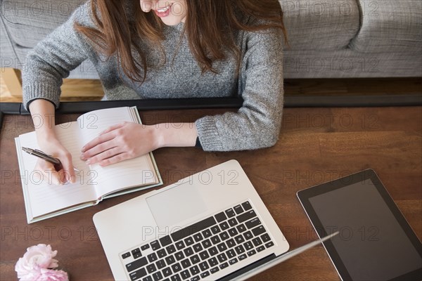 Caucasian woman writing in notebook