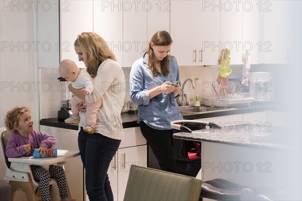 Caucasian mothers and daughters in kitchen