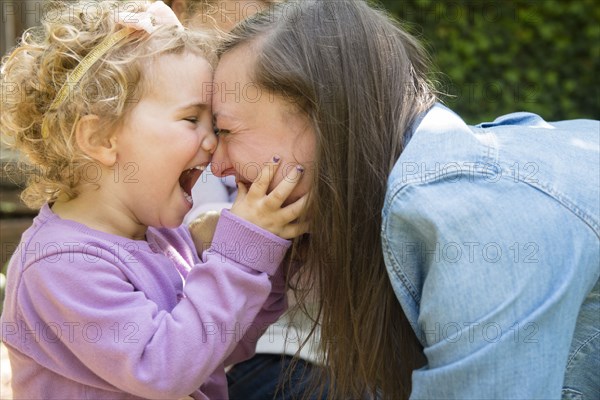 Caucasian mother and daughter laughing