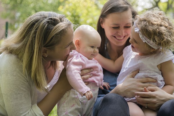 Caucasian mothers and daughters playing in park