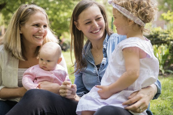 Caucasian mothers and daughters smiling in park