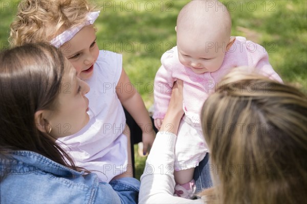 Caucasian mothers holding baby daughters